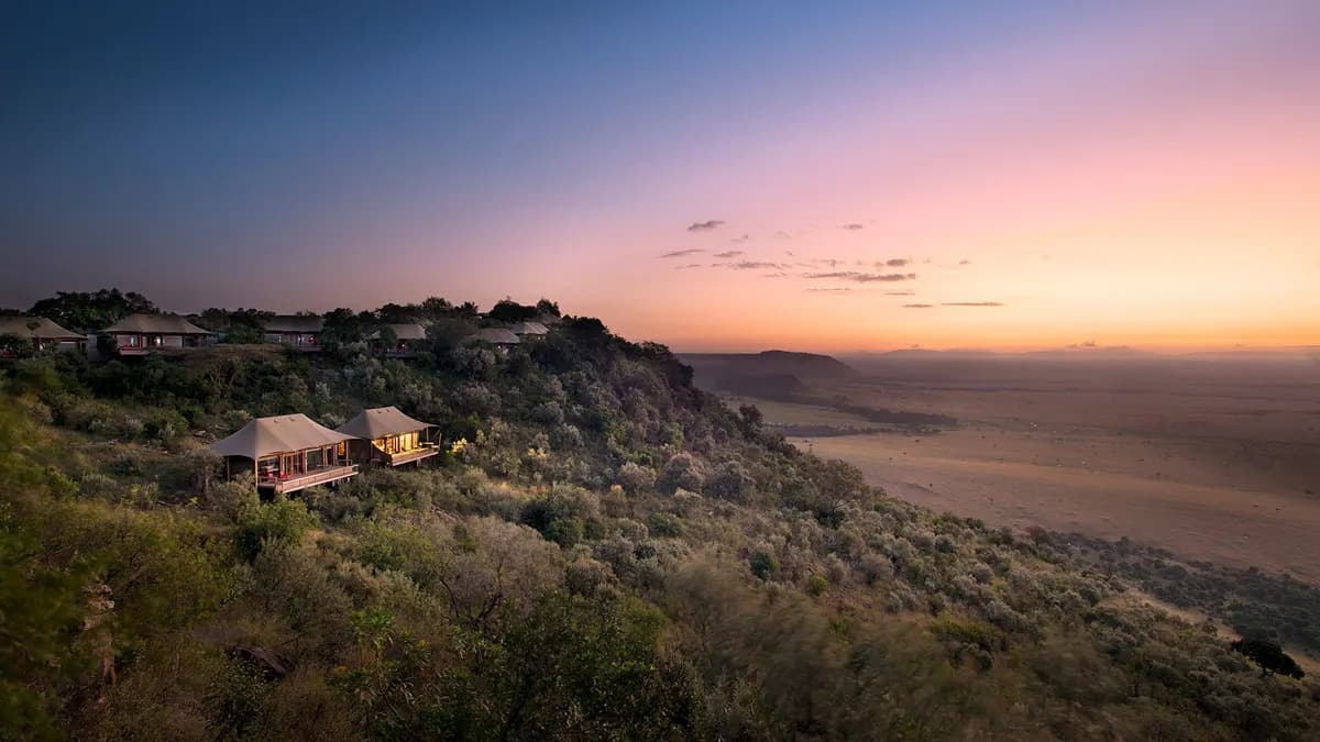 A luxurious safari lodge bedroom with a view of the savanna.
